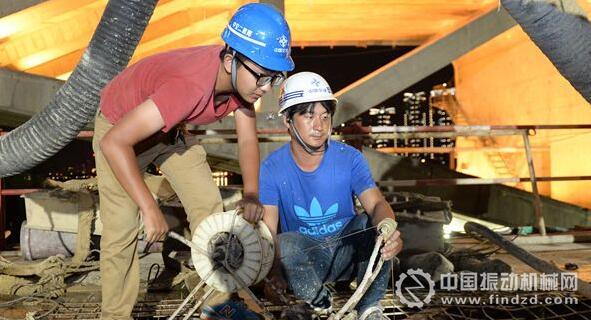 秦戈（左）用他革新過的測孔儀器測量深度