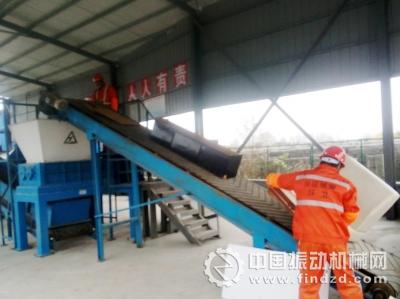 工人把舊沙發送上輸送帶