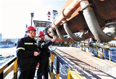 王琨（左）和蘭志學在回轉窯前探討技術難題