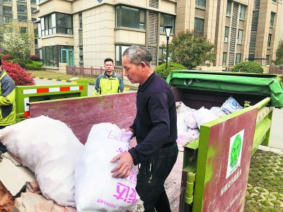 裝修工人將建筑垃圾裝袋后放入小區集中分類處置箱內