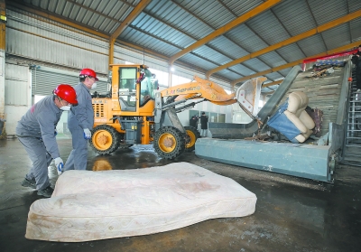 昨天，工人在秦淮區垃圾分類綜合處理中心對大件廢舊家具進行粉碎