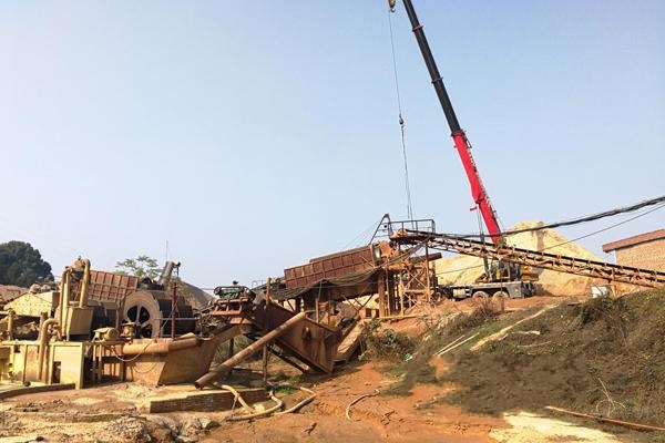 大吊車正在該沙場進行拆除作業，邊上堆滿了拆下來的設備。