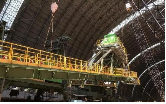 霍爾果斯口岸前，一臺(tái)臺(tái)大貨車整齊列隊(duì)，裝載著北方重工為烏茲別克斯坦在建的塔什干5000T/D熟料水泥生產(chǎn)線料工廠生產(chǎn)的5臺(tái)堆取料機(jī)產(chǎn)品